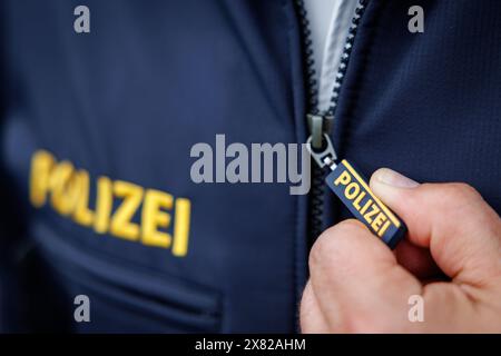 Nuremberg, Allemagne. 22 mai 2024. Le mot « police » est écrit sur la tirette de fermeture éclair et sur la veste d'un policier. Crédit : Daniel Karmann/dpa/Alamy Live News Banque D'Images