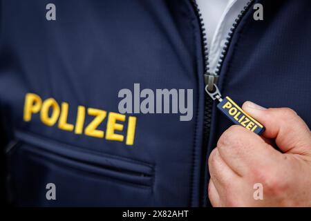 Nuremberg, Allemagne. 22 mai 2024. Le mot « police » est écrit sur la tirette de fermeture éclair et sur la veste d'un policier. Crédit : Daniel Karmann/dpa/Alamy Live News Banque D'Images
