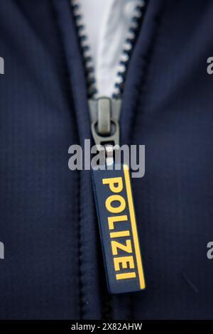 Nuremberg, Allemagne. 22 mai 2024. Le mot « police » est écrit sur la fermeture éclair de la veste d'un policier. Crédit : Daniel Karmann/dpa/Alamy Live News Banque D'Images