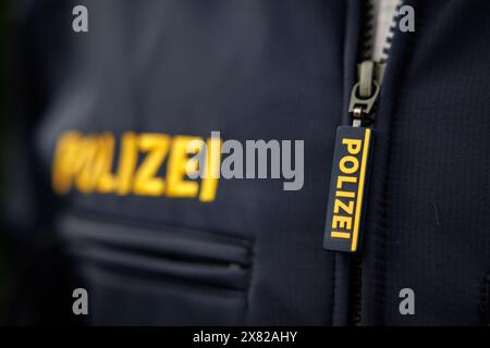 Nuremberg, Allemagne. 22 mai 2024. Le mot « police » est écrit sur la tirette de fermeture éclair et sur la veste d'un policier. Crédit : Daniel Karmann/dpa/Alamy Live News Banque D'Images
