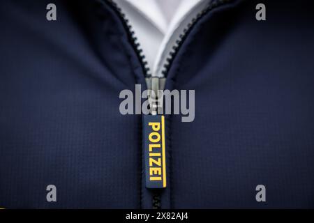 Nuremberg, Allemagne. 22 mai 2024. Le mot « police » est écrit sur la fermeture éclair de la veste d'un policier. Crédit : Daniel Karmann/dpa/Alamy Live News Banque D'Images