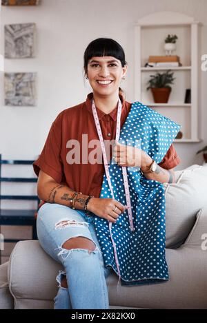 Maison, tailleur et femme avec tissu en portrait pour la fabrication, la production et costume fait main. Créatif, créateur de mode et fierté avec le vêtement Banque D'Images