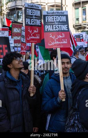 Londres, Royaume-Uni - 11 novembre 2023 : des manifestants tenant Freedom for Palestine signent lors du rassemblement de protestation pro-palestinien dans le centre de Londres, Royaume-Uni. Banque D'Images