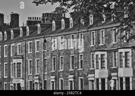 Photo en noir et blanc d'une rangée de maisons mitoyennes traditionnelles avec cheminées et lucarnes. Banque D'Images