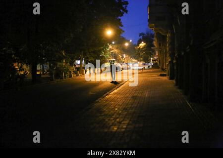 Odessa, région d'Odessa, Ukraine. 21 mai 2024. Un homme marche le long de la rue Preobrazhenskaya mal éclairée crise électrique à Odessa en raison du bombardement russe de l'infrastructure énergétique DTEK (la plus grande société privée verticalement intégrée d'énergie en Ukraine) introduit des coupures de courant quotidiennes pour les consommateurs. (Crédit image : © Viacheslav Onyshchenko/SOPA images via ZUMA Press Wire) USAGE ÉDITORIAL SEULEMENT! Non destiné à UN USAGE commercial ! Banque D'Images