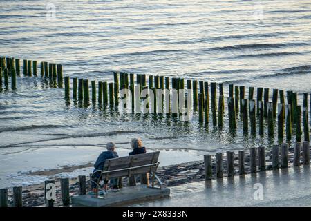 Zwei ältere Frauen auf einer Bank am Strand, BEI Flut, Wellenbrecher, Niederlande Senioren *** deux femmes âgées sur un banc sur la plage, à marée haute, brise-lames, pays-Bas Seniors Banque D'Images