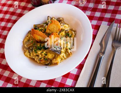 Œufs brouillés avec ceps, crevettes et oignon caramélisé Banque D'Images