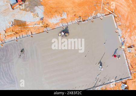 La fondation a été coulée avec des travailleurs du béton poli le béton à l'aide de machines de polissage du béton. Banque D'Images