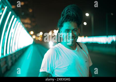 homme avec des dreads souriant dans la rue avec beaucoup de couleurs Banque D'Images