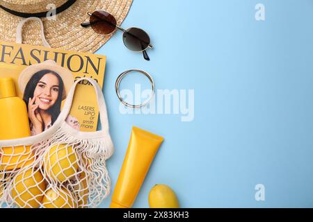 Sac à ficelle avec magazine, citrons et accessoires d'été sur fond bleu clair, pose plate. Espace pour le texte Banque D'Images
