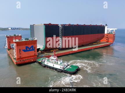 YANTAI, CHINE - 22 MAI 2024 - Un navire semi-submersible chargé de sections de coque d'un très grand porte-conteneurs se dirige vers l'assemblage final Banque D'Images