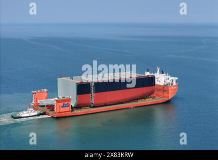 YANTAI, CHINE - 22 MAI 2024 - Un navire semi-submersible chargé de sections de coque d'un très grand porte-conteneurs se dirige vers l'assemblage final Banque D'Images