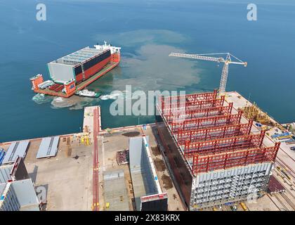 YANTAI, CHINE - 22 MAI 2024 - Un navire semi-submersible chargé de sections de coque d'un très grand porte-conteneurs se dirige vers l'assemblage final Banque D'Images