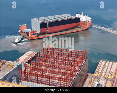 YANTAI, CHINE - 22 MAI 2024 - Un navire semi-submersible chargé de sections de coque d'un très grand porte-conteneurs se dirige vers l'assemblage final Banque D'Images