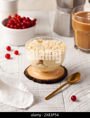 Élégant dessert Napoléon surmonté de pâtisserie émiettée, servi dans un bol sur un dessous de verre en bois Banque D'Images