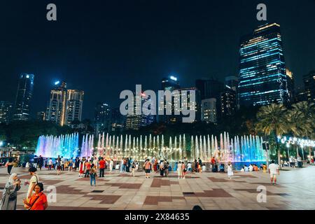 Kuala Lumpur, Malaisie - 12 mai 2024 : KLCC Suriya dans Petronas tours jumelles avec des touristes et des fontaines colorées Banque D'Images