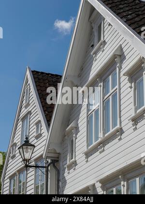 Gros plan de maisons en bois blanc et un lampadaire antique sous un ciel bleu, maisons en bois blanc dans un environnement verdoyant contre un ciel bleu Banque D'Images
