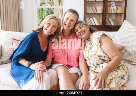 Diverses amies seniors partageant un moment chaleureux à la maison Banque D'Images