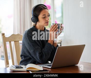 Femme, ordinateur portable et ordinateur portable à la maison pour l'entrepreneuriat, petite entreprise ou webinaire avec écouteurs. Femme personne, technologie et café dans la maison pour Banque D'Images