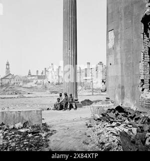 Charleston, S.C. vue des bâtiments en ruine à travers le porche de l'église circulaire (150 Meeting Street). Avril 1865. Photographe : George N. Barnard. Quatre enfants afro-américains sont assis à la base d'une grande colonne grecque. Photographies de la marine fédérale et des expéditions maritimes contre la côte atlantique de la Confédération -- plus précisément de Charleston, S.C. 1863-1865. Le succès du général Gillmore au fort Pulaski lui vaut la conduite d'une entreprise beaucoup plus difficile : la réduction des défenses du port de Charleston, avec l'aide d'un escadron sous les ordres du contre-amiral John A. Dahlgren. Opérations Beg Banque D'Images