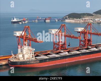 YANTAI, CHINE - 22 MAI 2024 - de gros navires déchargent des marchandises importées au port de Yantai, dans la province du Shandong de l'est de la Chine, le 22 mai 2024. Selon Banque D'Images