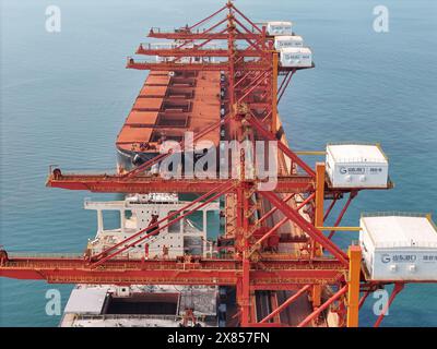 YANTAI, CHINE - 22 MAI 2024 - de grands cargos déchargent du minerai de bauxite importé et du charbon importé dans le port de Yantai, province du Shandong, Chine, le 22 mai Banque D'Images