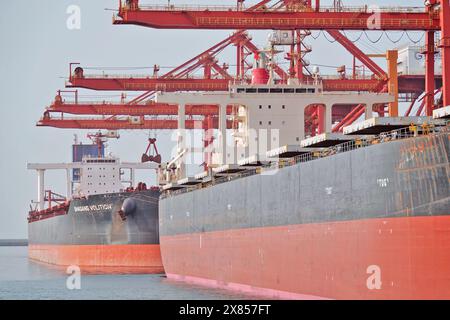 YANTAI, CHINE - 22 MAI 2024 - de grands cargos déchargent du minerai de bauxite importé et du charbon importé dans le port de Yantai, province du Shandong, Chine, le 22 mai Banque D'Images