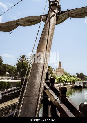 La tour médiévale du bastion de Séville appelée Torre del Oro vue depuis la réplique historique du navire Nao Victoria sur le fleuve Guadalquivir, Andalousie, Banque D'Images