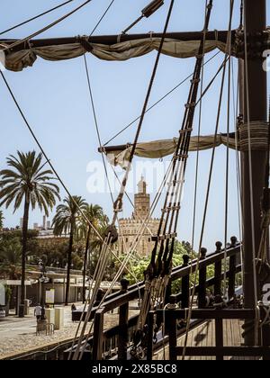 La tour médiévale du bastion de Séville appelée Torre del Oro vue depuis la réplique historique du navire Nao Victoria sur le fleuve Guadalquivir, Andalousie, Banque D'Images