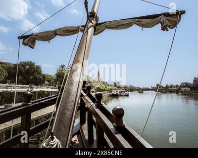 La tour médiévale du bastion de Séville appelée Torre del Oro vue depuis la réplique historique du navire Nao Victoria sur le fleuve Guadalquivir, Andalousie, Banque D'Images