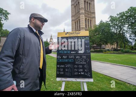 Westminster, Londres, Royaume-Uni. 23 mai 2024. Bookmaker, Sam Rosbottom offrant des cotes de Paris dans College Green sur le résultat de l'élection générale pour la société de Paris Betfair Exchange. Mercredi, le premier ministre Rishi Sunak a annoncé la date des élections générales britanniques qui se tiendront le 4 juillet, date à laquelle la nation se rendra aux urnes pour élire un nouveau gouvernement. Credit : amer Ghazzal/Alamy Live News Banque D'Images