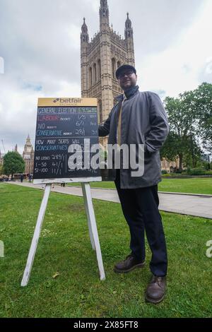 Westminster, Londres, Royaume-Uni. 23 mai 2024. Bookmaker, Sam Rosbottom offrant des cotes de Paris dans College Green sur le résultat de l'élection générale pour la société de Paris Betfair Exchange. Mercredi, le premier ministre Rishi Sunak a annoncé la date des élections générales britanniques qui se tiendront le 4 juillet, date à laquelle la nation se rendra aux urnes pour élire un nouveau gouvernement. Credit : amer Ghazzal/Alamy Live News Banque D'Images