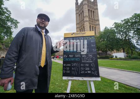 Westminster, Londres, Royaume-Uni. 23 mai 2024. Bookmaker, Sam Rosbottom offrant des cotes de Paris dans College Green sur le résultat de l'élection générale pour la société de Paris Betfair Exchange. Mercredi, le premier ministre Rishi Sunak a annoncé la date des élections générales britanniques qui se tiendront le 4 juillet, date à laquelle la nation se rendra aux urnes pour élire un nouveau gouvernement. Credit : amer Ghazzal/Alamy Live News Banque D'Images