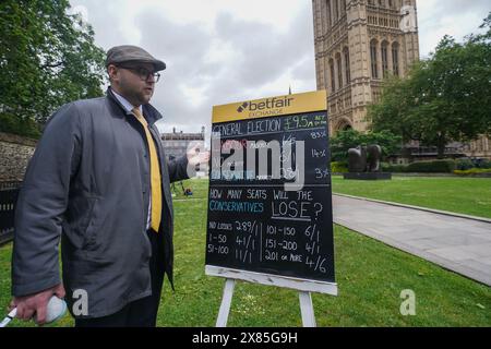 Westminster, Londres, Royaume-Uni. 23 mai 2024. Bookmaker, Sam Rosbottom offrant des cotes de Paris dans College Green sur le résultat de l'élection générale pour la société de Paris Betfair Exchange. Mercredi, le premier ministre Rishi Sunak a annoncé la date des élections générales britanniques qui se tiendront le 4 juillet, date à laquelle la nation se rendra aux urnes pour élire un nouveau gouvernement. Credit : amer Ghazzal/Alamy Live News Banque D'Images