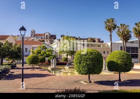 Statues dans une piscine ornementale dans la Praca al Mutamid avec la cathédrale et le château en arrière-plan, Silves, Portugal Banque D'Images