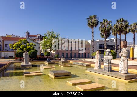 Statues dans une piscine ornementale dans la Praca al Mutamid avec la cathédrale au loin, Silves, Portugal Banque D'Images