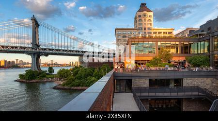 New York City, Brooklyn, DUMBO : les gens font du shopping et profitent des derniers rayons du coucher de soleil au centre commercial Empire Stores. Empire Fulton Ferry Park Banque D'Images