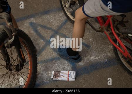 Beyrouth, Liban. 18 mai 2024. Des enfants montent à vélo et piétinent un drapeau israélien peint dans la rue du camp de réfugiés de Bourj el-Brajneh, Beyrouth, Liban, le 18 mai 2024. Environ 25 000 Palestiniens vivent à Bourj el-Brajneh. (Photo de Collin Mayfield/Sipa USA) crédit : Sipa USA/Alamy Live News Banque D'Images