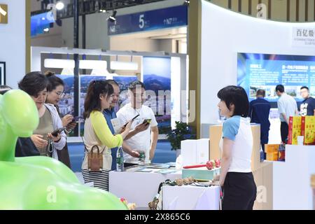 Chongqing. 23 mai 2024. Les gens visitent la sixième foire internationale de l'investissement et du commerce de Chine occidentale au Centre d'exposition international de Chongqing dans la municipalité de Chongqing, dans le sud-ouest de la Chine, le 23 mai 2024. Avec le thème de «Nouvelle Chine occidentale, Nouvelle fabrication, nouveaux services», la foire se tient du 23 au 26 mai à Chongqing. Crédit : Zhang Ziyu/Xinhua/Alamy Live News Banque D'Images