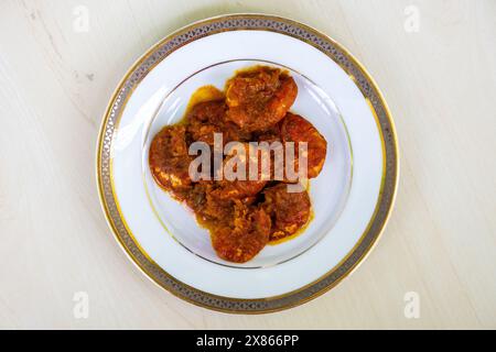 Délicieux chingri bhuna de nourriture bengali servi sur une assiette blanche. Le Chingri vuna ou curry de crevettes est un plat de style bangladais avec une sauce épicée. Vue de dessus. Banque D'Images