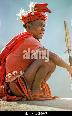 Philippines, Luzon ; homme de la tribu Ifugao. Traditionnellement habillé de plumes dans un bandeau de tête et tenant une lance. Banque D'Images