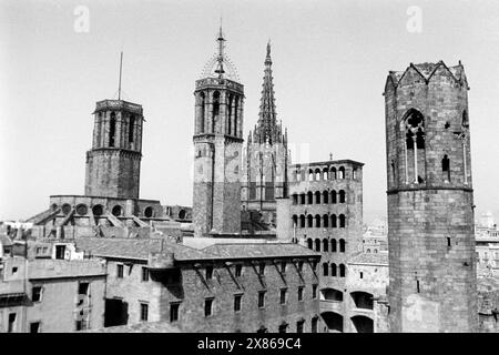 Die drei Türme der Kathedrale von Barcelona, der hintere rechte trägt den eisernen Glockenkäfig mit Glocke, mittig die vielen Fenster des Aussichtsturms des Rey Martín sowie rechts der Turm des Palacio Real, Spanien 1957. Les trois tours de la cathédrale de Barcelone, la tour arrière à droite porte la cage de fer avec cloche, au centre les nombreuses fenêtres de la tour d'observation Rey Martín et à droite la tour du Palacio Real, Espagne 1957. Banque D'Images