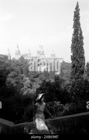 Eine Junge Frau erklimmt eine Treppe, im Hintergrund ist der Palau Nacional von Barcelona erkennbar, 1957.Une jeune femme monte un escalier, le Palau Nacional de Barcelone est reconnaissable en arrière-plan, 1957. Banque D'Images