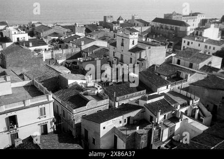 Blick vom Glockenturm auf die umliegende Ortschaft von Calella an der Costa del Maresme, im Hintergrund ist die Oberfläche des Mittelmeeres erkennbar, Katalonien 1957. Vue depuis le clocher du village environnant de Calella sur la Costa del Maresme, avec la surface de la mer Méditerranée visible en arrière-plan, Catalogne 1957. Banque D'Images