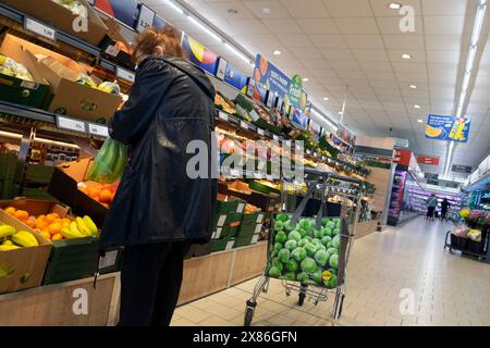 Arrière arrière arrière vue arrière de la femme plus âgée shopper achetant des fruits et légumes dans Lidl supermarché chariot sac de transport intérieur magasin magasin UK 2024 KATHY DEWITT Banque D'Images