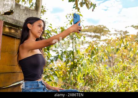 lifestyle : belle jeune latina qui aime être à l'extérieur prend un selfie avec son smartphone Banque D'Images