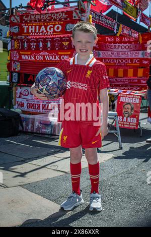 LIVERPOOL, ANGLETERRE - 19 MAI : garçon de neuf ans dans les rues d'Anfield avec fièrement un ballon de football. Angleterre Banque D'Images