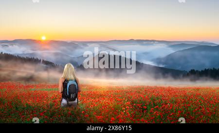 Une jeune femme debout dans un champ coloré de coquelicots sauvages au Tyrol, en Autriche Banque D'Images