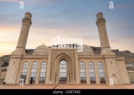 La mosquée Bibi-Heybat se dresse au coucher du soleil à Bakou, Azerbaïdjan. Les dômes des mosquées, les minarets et les détails architecturaux complexes sont bien en vue sur le ciel crépusculaire Banque D'Images
