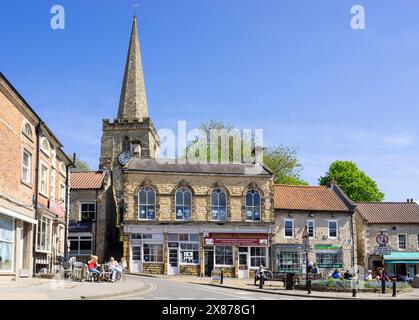 Pickering magasins sur la place du marché et Birdgate avec la tour de St Peter et St Paul's Church Pickering North Yorkshire Angleterre UK GB Europe Banque D'Images